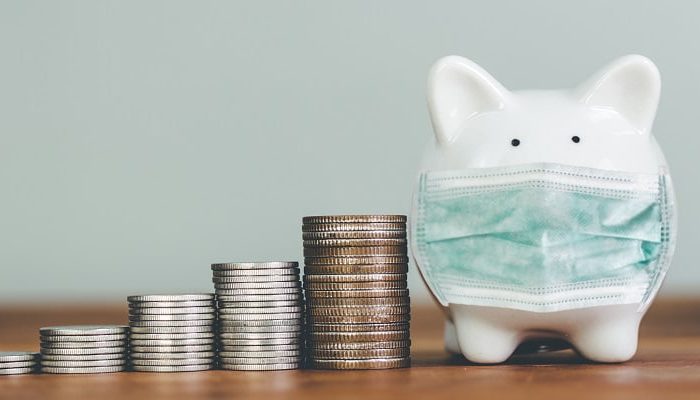 piggybank in surgical mask - cash flow issues related to COVID-19