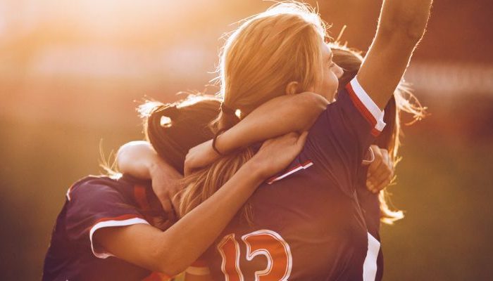 college athletes celebrating on soccer field