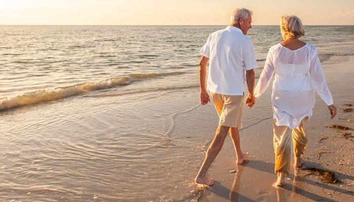 retirement planning - couple walking on beach